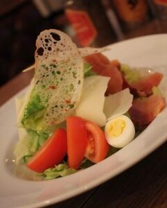 Салат с копченой горбушей, Пармезаном, томатами, яйцом и гренками